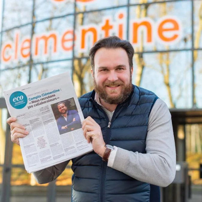 Photo d'un comptable qui tient un journal Économie avec un article sur Clementine