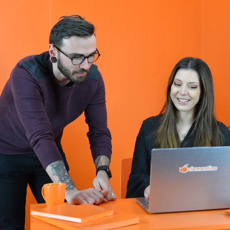 Photo d'un comptable en rendez-vous avec un client dans une salle entièrement orange